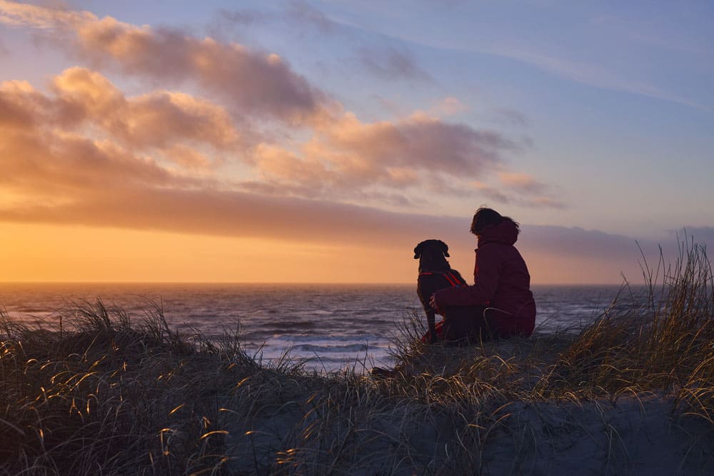 Frau mit Hund im Urlaub am Strand auf Usedom